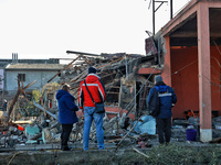 People stand among the debris of a damaged building after an overnight Russian drone attack in Odesa, Ukraine, on November 8, 2024. One pers...