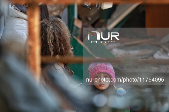 A girl stands near a building damaged by an overnight Russian drone attack in Odesa, Ukraine, on November 8, 2024. One person dies and nine...