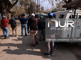 Journalists shoot video as Indian army vehicles leave the encounter site after killing two militants in Sopore, Jammu and Kashmir, India, on...