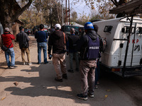 Journalists shoot video as Indian army vehicles leave the encounter site after killing two militants in Sopore, Jammu and Kashmir, India, on...