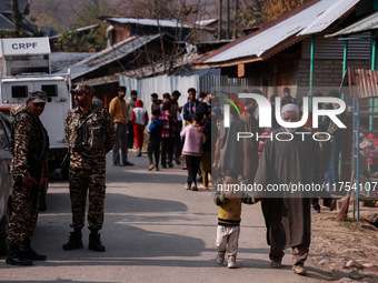 An elderly man walks while holding a child towards the encounter site where two militants are killed in Sopore, Jammu and Kashmir, India, on...