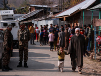 An elderly man walks while holding a child towards the encounter site where two militants are killed in Sopore, Jammu and Kashmir, India, on...