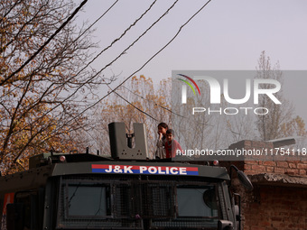 A girl and a boy (siblings) watch the Indian soldiers who engage in an encounter with militants in Sopore, Jammu and Kashmir, India, on Nove...