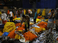 Vendors sell garlands of marigold flowers at a wholesale flower market during dawn on the banks of the river Ganges in Kolkata, India, on No...