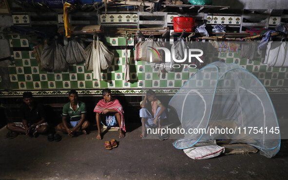 Daily wage workers wait for employment at a wholesale flower market during dawn on the banks of the river Ganges in Kolkata, India, on Novem...