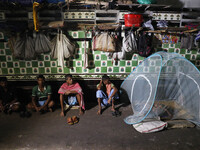 Daily wage workers wait for employment at a wholesale flower market during dawn on the banks of the river Ganges in Kolkata, India, on Novem...