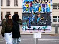 People pass artworks lined up in a four-kilometre-long open-air installation a day ahead of the 35th anniversary of the fall of the Berlin W...