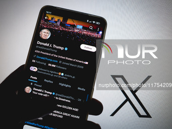 The X (Twitter) account of Donald J. Trump appears on a smartphone screen with the Twitter logo in the background in Athens, Greece, on Nove...