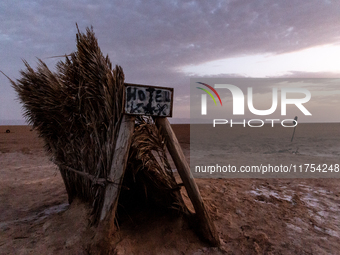 A 'hotel' sign is seen on a grass tent as sun rises over Chott el Djerid salt lake in eastern Sahara, Tunisia on October 29, 2024. Chott el...