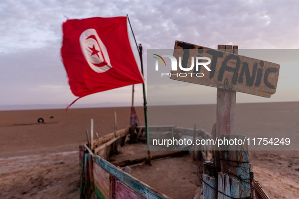 A 'titanic' sign is seen on a wooden boat with Tunisia flag as sun rises over Chott el Djerid salt lake in eastern Sahara, Tunisia on Octobe...