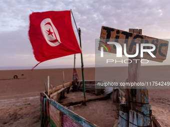 A 'titanic' sign is seen on a wooden boat with Tunisia flag as sun rises over Chott el Djerid salt lake in eastern Sahara, Tunisia on Octobe...