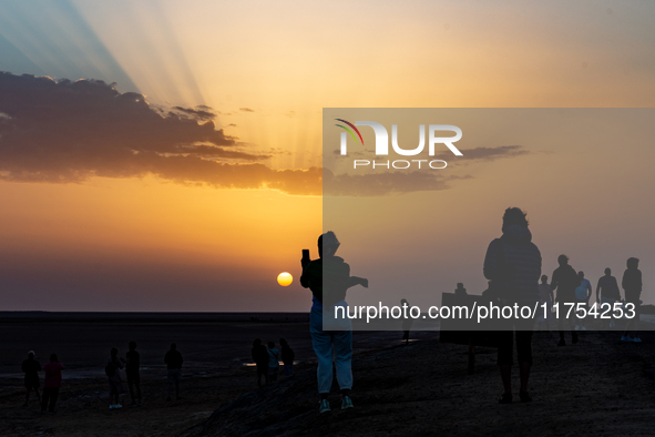 Tourists take photos as sun rises over Chott el Djerid salt lake in eastern Sahara, Tunisia on October 29, 2024. Chott el Djerid is the bigg...