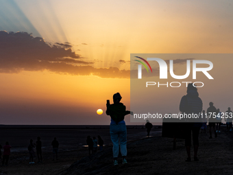 Tourists take photos as sun rises over Chott el Djerid salt lake in eastern Sahara, Tunisia on October 29, 2024. Chott el Djerid is the bigg...