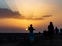 Tourists take photos as sun rises over Chott el Djerid salt lake in eastern Sahara, Tunisia on October 29, 2024. Chott el Djerid is the bigg...