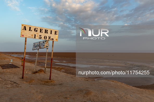 A 'Algerie 150km' sign is seen as sun rises over Chott el Djerid salt lake in eastern Sahara, Tunisia on October 29, 2024. Chott el Djerid i...