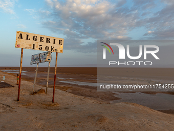 A 'Algerie 150km' sign is seen as sun rises over Chott el Djerid salt lake in eastern Sahara, Tunisia on October 29, 2024. Chott el Djerid i...