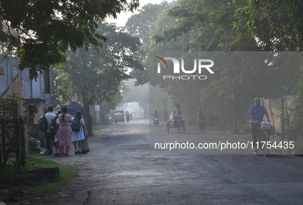 People stand on the street on a polluted, smoggy morning in Kolkata, India, on November 8, 2024. 