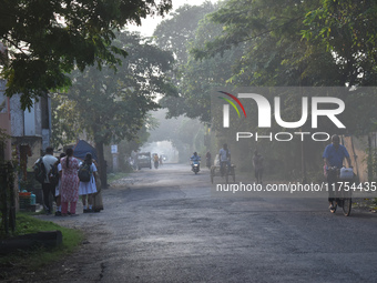 People stand on the street on a polluted, smoggy morning in Kolkata, India, on November 8, 2024. (