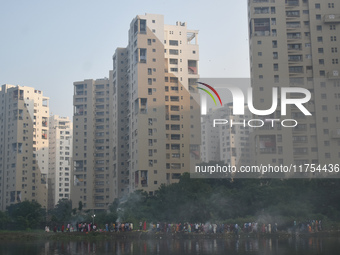 People celebrate the Chhath festival on a polluted, smoggy morning in Kolkata, India, on November 8, 2024. (