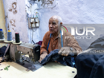 A tailor works in his workshop in an Old Town of Kairouan in central Tunisia on October 31, 2024. (