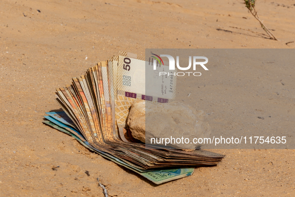 Tunisian Dinar is seen on a sand in Douz in Sahara desert, Tunisia on October 30, 2024. 