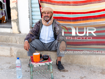 A man sits on a street wit his tea in Tozeur in central Tunisia on October 29, 2024. (