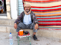 A man sits on a street wit his tea in Tozeur in central Tunisia on October 29, 2024. (