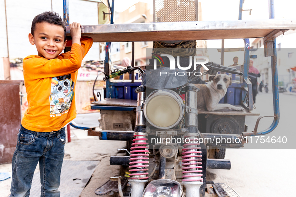 A boy stands by a motorbike in Tozeur in central Tunisia on October 28, 2024. 