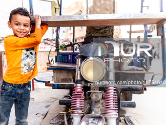 A boy stands by a motorbike in Tozeur in central Tunisia on October 28, 2024. (