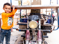 A boy stands by a motorbike in Tozeur in central Tunisia on October 28, 2024. (