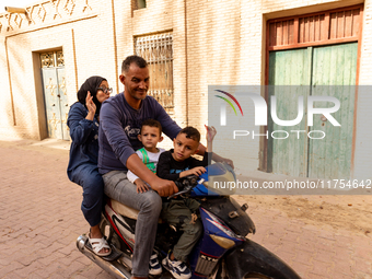 A family rides on a motorbike in Medina of Tozeur in central Tunisia on October 28, 2024. (