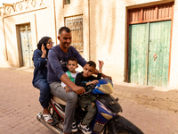 A family rides on a motorbike in Medina of Tozeur in central Tunisia on October 28, 2024. (