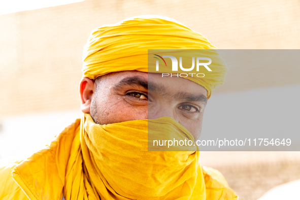 A bedouin poses to be photographed in yellow scarf on a street in Tozeur in central Tunisia on October 28, 2024. 