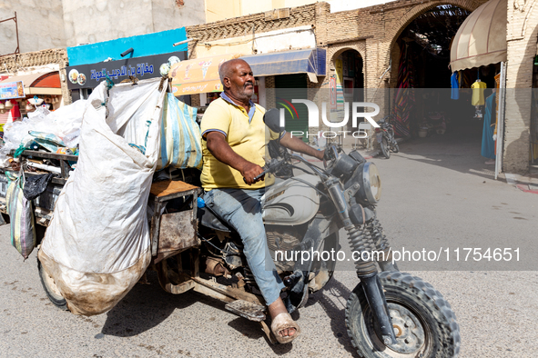 A man rides a motorbike  packed with various goods on a street in Tozeur in central Tunisia on October 28, 2024. 