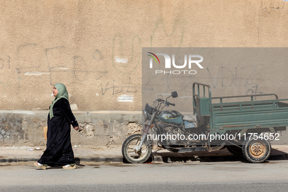 A woman in hijab walks on a street in Tozeur in central Tunisia on October 28, 2024. 