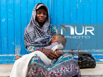 A woman sits with her baby in an Old Town of Soussa, Tunisia on November 2, 2024. (