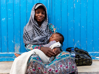 A woman sits with her baby in an Old Town of Soussa, Tunisia on November 2, 2024. (