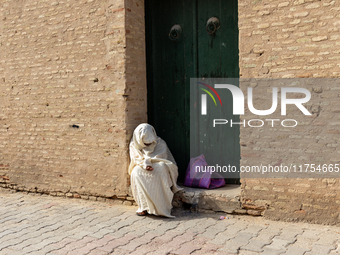 A woman begs in an Old Town of Kairouan in central Tunisia on October30, 2024. (