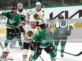 Esa Lindell #23 of the Dallas Stars and Jason Dickinson #16 of the Chicago Blackhawks play during the NHL match at American Airlines Center...