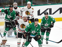 Esa Lindell #23 of the Dallas Stars and Jason Dickinson #16 of the Chicago Blackhawks play during the NHL match at American Airlines Center...