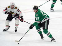 Thomas Harley #55 of the Dallas Stars and Jason Dickinson #16 of the Chicago Blackhawks battle for the puck during the NHL match at American...