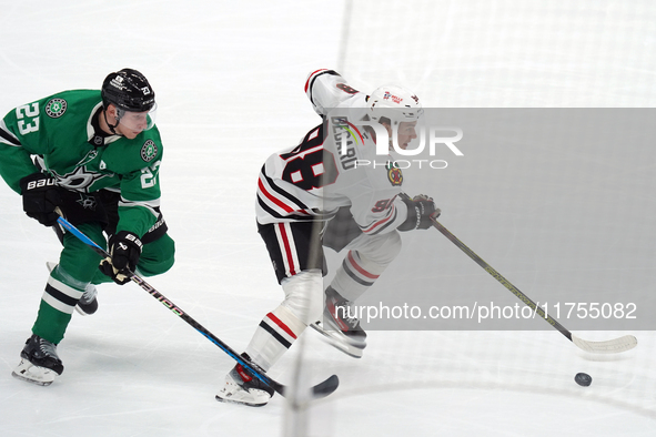 Esa Lindell #23 of the Dallas Stars and Connor Bedard #98 of the Chicago Blackhawks battle for the puck during the NHL match at American Air...