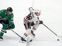 Esa Lindell #23 of the Dallas Stars and Connor Bedard #98 of the Chicago Blackhawks battle for the puck during the NHL match at American Air...