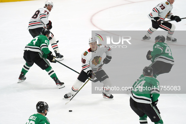 Connor Bedard #98 of the Chicago Blackhawks controls the puck during the NHL match against the Dallas Stars at American Airlines Center in D...