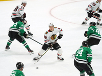 Connor Bedard #98 of the Chicago Blackhawks controls the puck during the NHL match against the Dallas Stars at American Airlines Center in D...