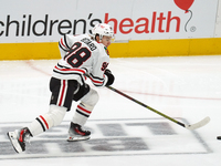 Connor Bedard #98 of the Chicago Blackhawks skates on the ice while driving forward with the puck during the NHL match against the Dallas St...