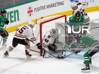 Connor Murphy #5 and goalkeeper Arvid Soderblom of the Chicago Blackhawks defend against Wyatt Johnston #53 of the Dallas Stars during the N...