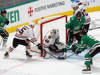 Connor Murphy #5 and goalkeeper Arvid Soderblom of the Chicago Blackhawks defend against Wyatt Johnston #53 of the Dallas Stars during the N...