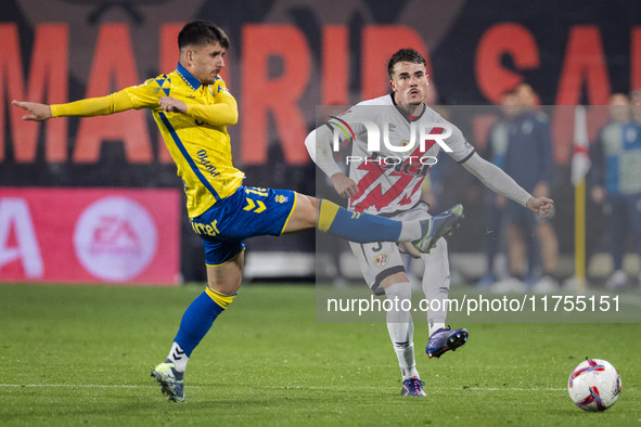 Pep Chavarria of Rayo Vallecano (R) is in action against Manu Fuster of UD Las Palmas (L) during the La Liga EA Sports 2024/25 football matc...