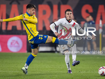 Pep Chavarria of Rayo Vallecano (R) is in action against Manu Fuster of UD Las Palmas (L) during the La Liga EA Sports 2024/25 football matc...